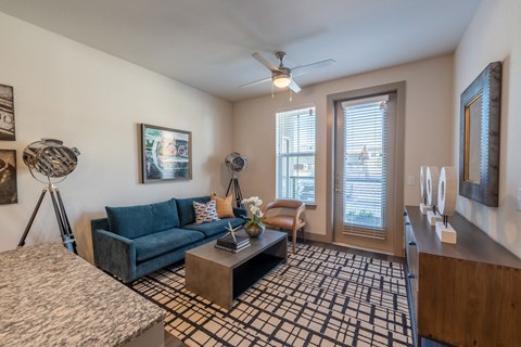 an open living room with a blue couch and a coffee table